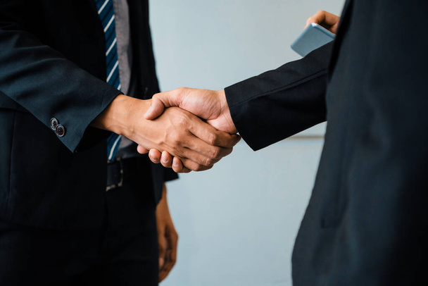 Концепция соглашения деловых людей. Бизнесмен пожимает руку другому бизнесмену в конференц-зале. uds - Фото, изображение