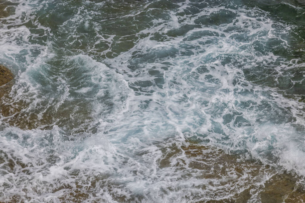 Tło, tekstura ukazująca wygląd piankowych wód wzdłuż wybrzeża Atlantyku. - Zdjęcie, obraz