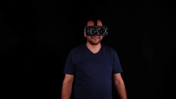 VR okulary, człowiek w okularach VR i czarne tło - Materiał filmowy, wideo