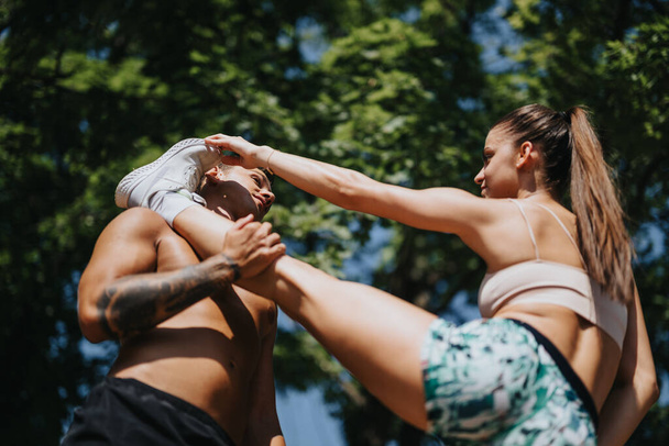 Активная пара фитнес-тренировка на открытом воздухе, мотивированные друзья, наслаждающиеся тренировкой в солнечном парке - Фото, изображение