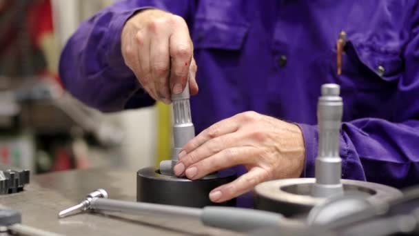Cnc fabrikasında metal parçaları birleştiren bir işçinin ellerinin yakın çekim videosu. - Video, Çekim
