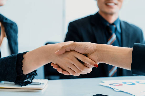 Концепция соглашения деловых людей. Бизнесмен и азиатская бизнесвумен пожимают друг другу руки в офисе. uds - Фото, изображение