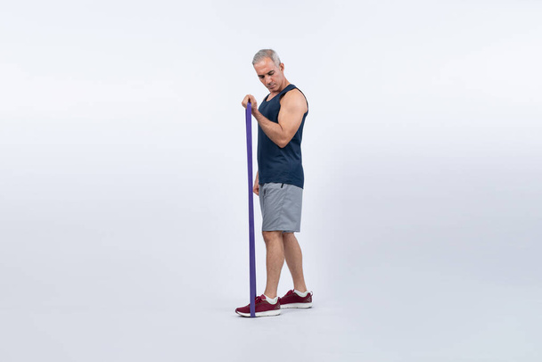 Celotělová délka záběr atletický a sportovní senior muž s fitness odolnost pásmo na izolovaném pozadí. Zdravý aktivní tělo a péče o tělo životní styl po odchodu do důchodu. Clovek - Fotografie, Obrázek