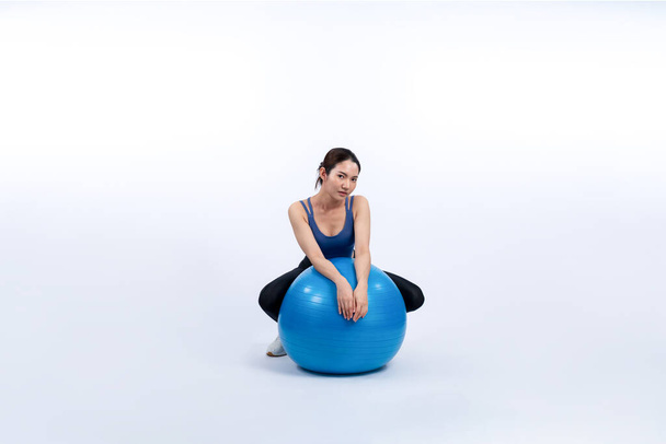 Young attractive asian woman portrait in sportswear with fit ball targeting on abs muscle for effective energetic daily workout routine. Studio shot and isolated background. Vigorous - Foto, Imagem