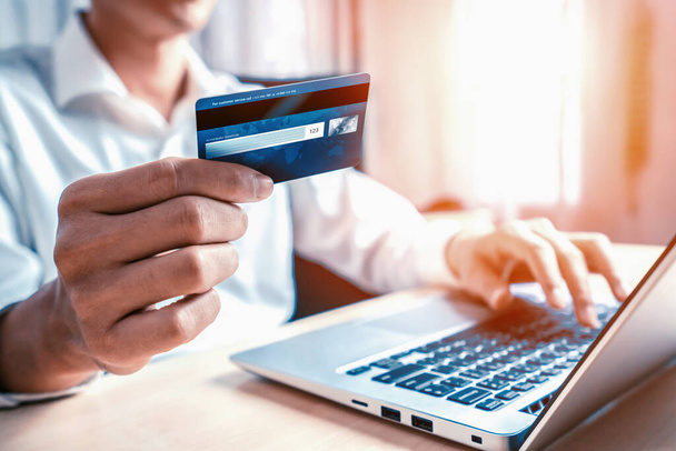 Fiatalember használja hitelkártya vásárlás fizetés online laptop számítógépes alkalmazás vagy weboldal. Elektronikus kereskedelem és online vásárlási koncepció. uds - Fotó, kép
