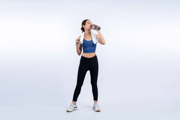 Sportos és sportos ázsiai nő pihen és iszik vizet intenzív kardio edzés után. Egészséges testmozgás és fitt testápolás életmód hajsza stúdió lövés elszigetelt háttér. Élénk. - Fotó, kép