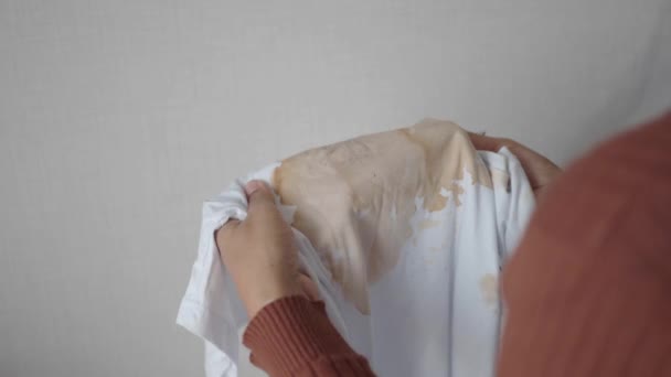  жінки, що тримають брудну сорочку білого кольору, показують, що роблять плями. - Кадри, відео