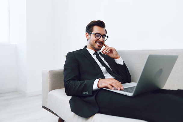 Успішний чоловік бізнес тисячолітній хлопець відео домашній диван диван білий мережа онлайн чоловік молодий дивлячись Інтернет усміхнений позаштатний ноутбук окуляри дивитися домашній виклик - Фото, зображення
