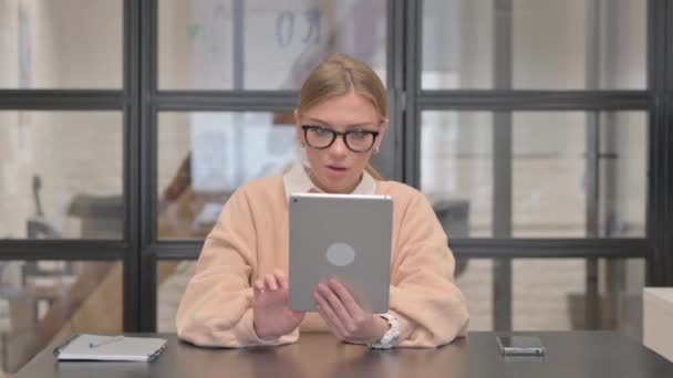 Νεαρή γυναίκα γιορτάζει την επιτυχία στο Tablet στο γραφείο - Πλάνα, βίντεο