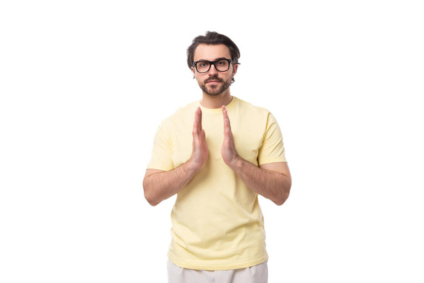 junger smarter brünetter Mann in T-Shirt und Brille auf weißem Hintergrund mit Kopierraum. - Foto, Bild
