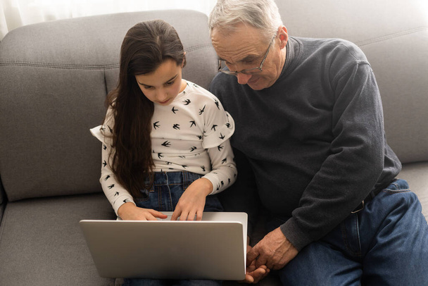 Grand-père et petite-fille avec ordinateur portable
. - Photo, image