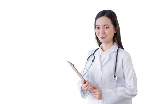 Professional beautiful young woman doctor holding document in clipboard smiling looking at camera while she wears white lab coat and stethoscope in hospital while isolated on white background. Health concept. - Photo, Image