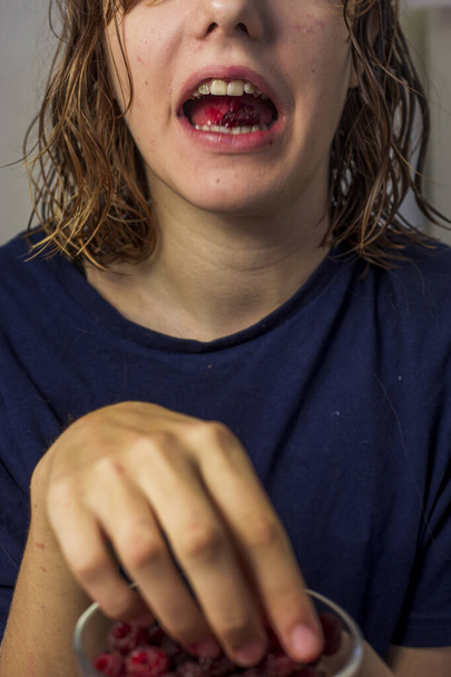 adolescente come framboesas vermelhas azedas com a boca bem aberta - Foto, Imagem