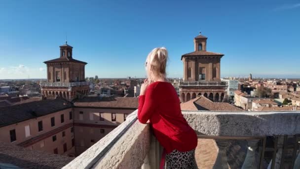 Toeristische vrouw die het Ferrara kasteel van Italië bezoekt. Omringd door brede gracht gevuld met water, waardoor het een gevoel van isolatie en bescherming geeft. Het kasteel heeft een vierkante vorm met 4 massieve torens. - Video