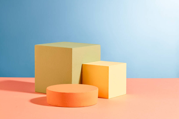 Three podiums in round and cube shaped are decorated against blue background. Pastel minimal wall scene collection. Modern platform for product display presentation - Photo, Image