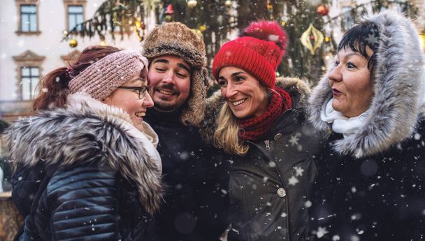 Onnellisia ystäviä kokoontui juhlava joulumarkkinat lumessa - Valokuva, kuva