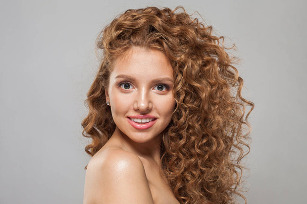 Modelo de moda mulher ruiva sorridente com cabelos castanhos encaracolados brilhantes e pele fresca saudável natural no fundo branco. Cosmetologia, cabeleireiro e conceito de tratamento de beleza - Foto, Imagem