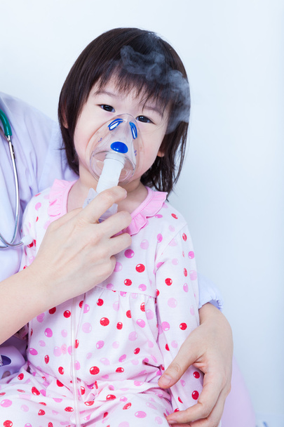 El médico ayuda a la niña a inhalar
 - Foto, imagen