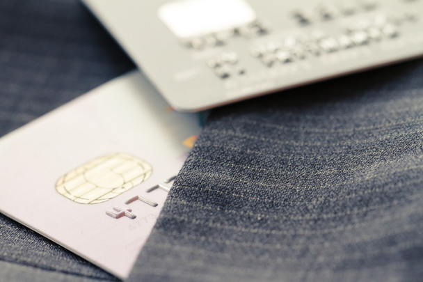 Tarjetas de crédito en enfoque muy superficial con fondo de traje gris
 - Foto, imagen