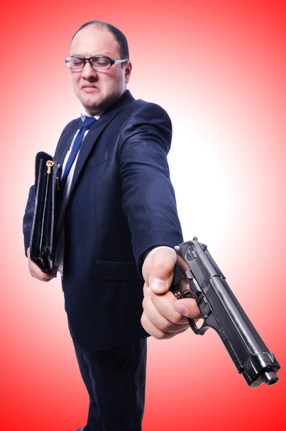 Businessman with gun on red - Photo, Image