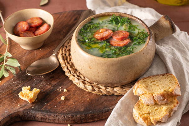 Caldo verde népszerű leves a portugál konyha. A caldo verde hagyományos összetevői a burgonya, a hagyma, a fokhagyma, a galléros zöldségek, a chorizo, az olívaolaj és a só. Ez egy vigaszleves, és általában kukoricakenyérrel tálalják. - Fotó, kép