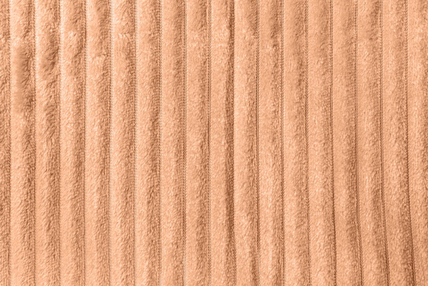Color of the year 2024 Peach Fuzz. Trendy color concept. Soft fleece throw fabric with lines - Photo, Image