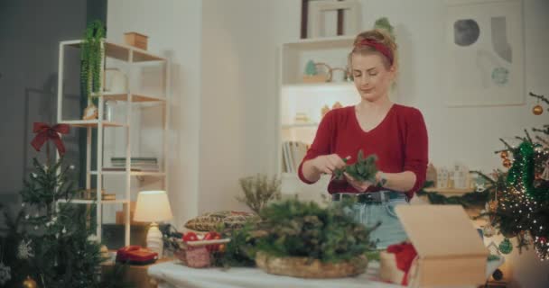 View of Woman Preparing Christmas Decorations. Woman Preparing Christmas Wreath Garland For Christmas Holidays. Florist Creating Christmas Wreath In Workshop. - Footage, Video