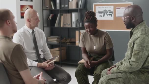 Plný střední snímek afroamerické ženy pláče při rozhovoru během skupinové terapie s psychiatrem a různými kolegy důstojníky uvnitř - Záběry, video