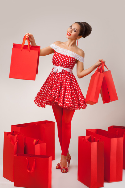 Happy Woman Holding Up Shopping Bags. Pin-up retro style. - Fotó, kép