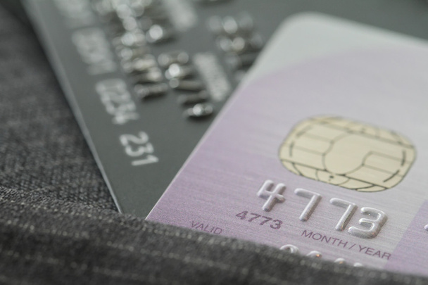Tarjetas de crédito en enfoque muy superficial con fondo de traje gris como
  - Foto, imagen