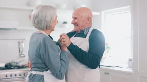 Senior couple, dancing and kitchen with cooking, smile and love in a home with retirement and marriage. Support, music and elderly people together with bonding, date and happy in a house with care. - Footage, Video