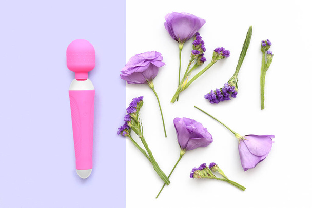 Розовый вибратор из секс-шопа и красивые цветы на цветном фоне - Фото, изображение