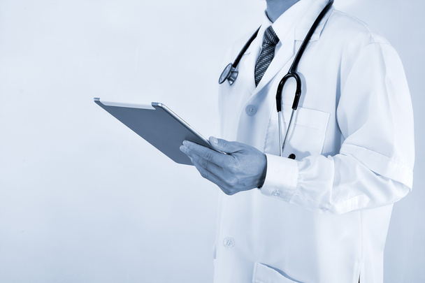 Blurred Doctor working on a digital tablet - Foto, afbeelding