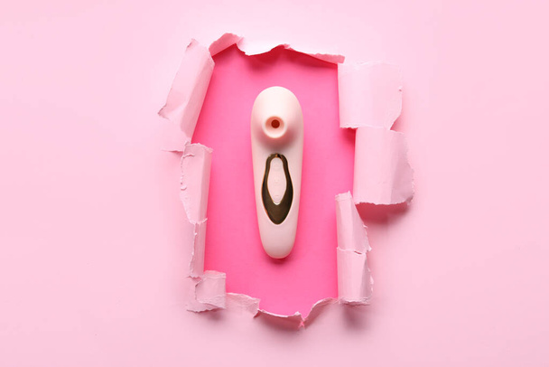 Вибратор виден сквозь рваную розовую бумагу - Фото, изображение
