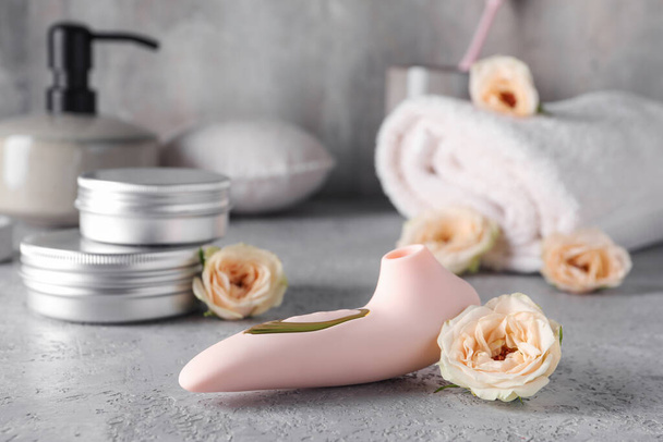 Vibrator with flowers on grunge table, closeup - Photo, Image