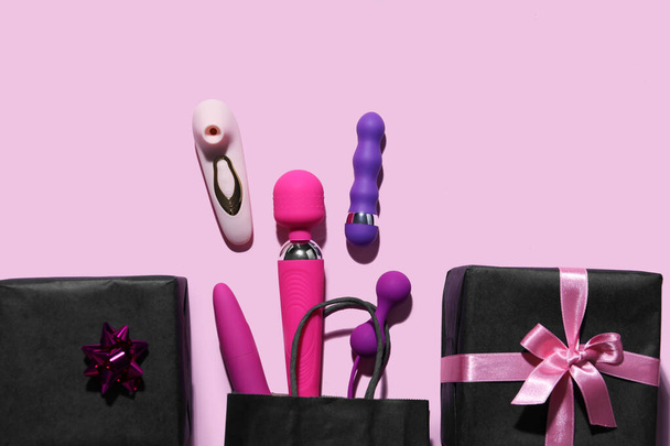 Bolsa con juguetes sexuales y regalos sobre fondo rosa - Foto, Imagen