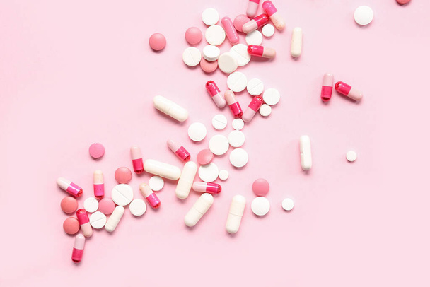 Muchas píldoras diferentes sobre fondo rosa - Foto, imagen