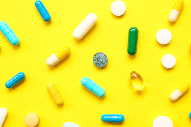muitas pílulas diferentes no fundo amarelo
 - Foto, Imagem