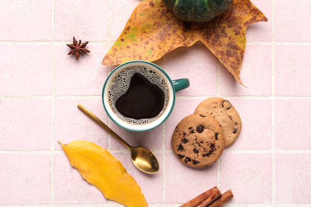 Složení s šálkem aromatické kávy, sušenek a spadlých listů na barevné dlaždice pozadí - Fotografie, Obrázek