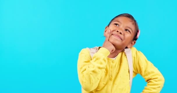Thinking, smile and girl child in studio with question, why and choice on blue background. Happy, idea or kid student with decision, emoji and plan for back to school, answer and excited about future. - Footage, Video