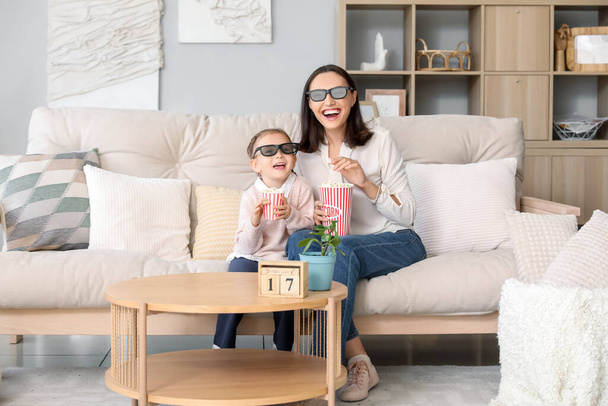 Красива мати і її мила маленька дочка в 3D окулярах кіно з попкорном дивитися фільм вдома - Фото, зображення