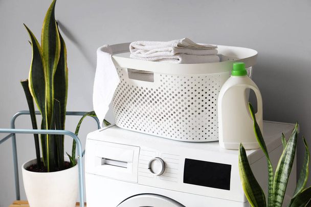 Wäschekorb mit Handtüchern und Waschmittel auf Waschmaschine, Nahaufnahme - Foto, Bild