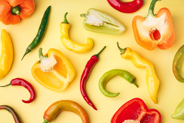 Διαφορετικές φρέσκες πιπεριές σε κίτρινο φόντο - Φωτογραφία, εικόνα