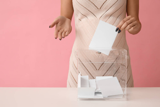 Raskaana olevan naisen äänestyslippu lähellä vaaleja laatikko vaaleanpunainen tausta - Valokuva, kuva