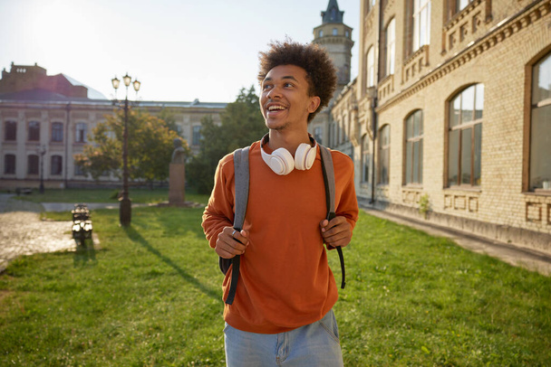 Portrét mladistvého studenta, který se prochází mezi budovami univerzitního kampusu. Zpět na proces offline vzdělávání - Fotografie, Obrázek