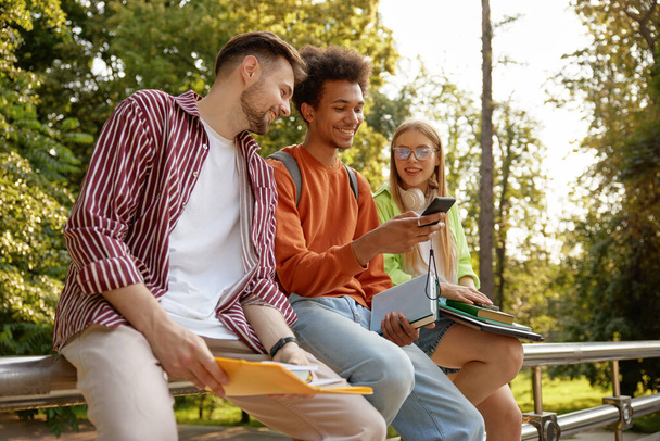Lässige Teenager lachen und teilen gute Laune. Freunde verbringen Zeit nach dem College-Unterricht im Freien - Foto, Bild