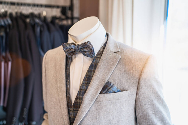 Manequim vestido com um terno cinza claro com um laço xadrez e combinando bolso quadrado - Foto, Imagem