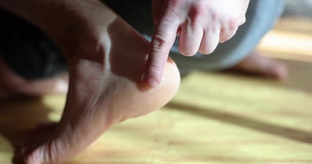 Uomo sfregamento ruvida pelle secca dei piedi con crema idratante primo piano 4k film al rallentatore. concetto di cura della pelle - Filmati, video