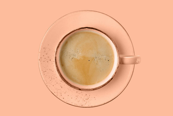 Рожевий кораловий старовинний стакан гарячої кави, що летить ізольовано на фоні персикового фугасу. Порцелянова чашка в модному кольорі 2024 року Peach Fuzz. - Фото, зображення