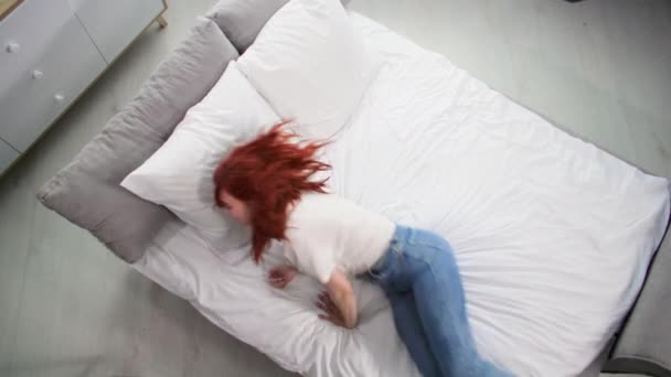 femme heureuse sautant sur le lit pour se détendre à la maison, vue de dessus - Séquence, vidéo